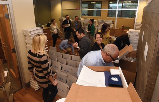 Photo by Phil Jones. Communications and Marketing staff assemble 1,000 brand starter kits for launch day delivery.