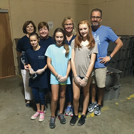 Dean Lefebvre and daughter Caitlin (second from left) sorted books at Goodwill's Good Books Cafe with Betty Meehan of the Office of Advancement (left) and Drs. Scott De Rossi and Kate Ciarrocca and their daughters, Sofia and Evie.