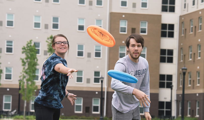 Jessica Fleming and James Crockett play Frisbee on the Jaguar Park greenspace.