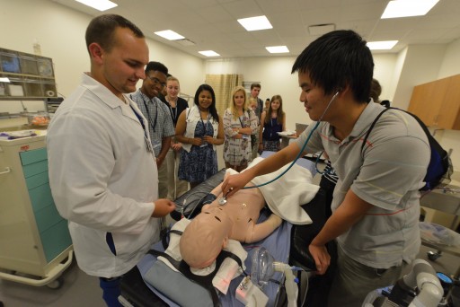 Thomas Fu uses a stethoscope in a simulation lab.